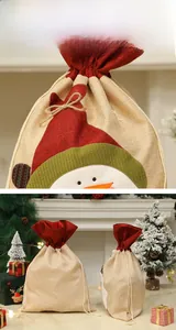 Détail d'un sac cadeau de Noël en lin avec motif bonhomme de neige et cordon rouge