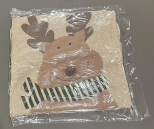 Détail d'un sac cadeau de Noël en toile de jute avec motif renne sous emballage plastique