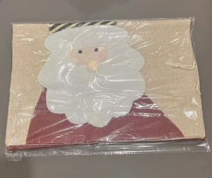Détail d'un sac de Noël en toile de jute avec appliqué Père Noël sous emballage plastique