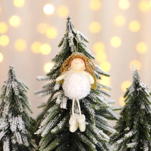 Ange de Noël en peluche avec ailes dorées sur sapin enneigé et fond de lumières floues