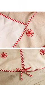 Close-up of faux linen Christmas tree skirt with red snowflakes and striped edges