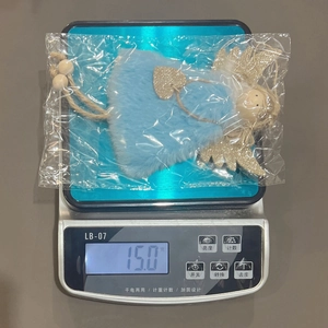 Vue détaillée d'un ange en peluche bleue fait main pesant 15,0 grammes sur une balance