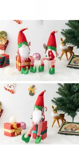 Close-up of Christmas gnomes with striped legs and golden bells on a festive background