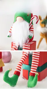 Detailed view of plush Christmas gnome with green hat and striped candy cane decor