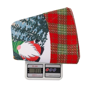 Detailansicht des 311g schweren Weihnachtsstoffes mit Wichteldruck und Schottenkaro-Muster