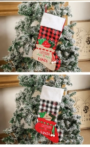Detail of embroidered Christmas stockings with plaid patterns and Santa Claus lettering