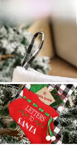 Detail of red and green Christmas stockings with Santa Claus embroidery and plaid hanging rope