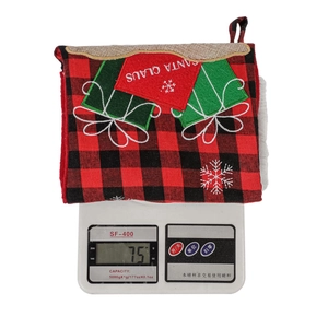 Macro view showing the 75g weight of a red plaid Christmas stocking gift bag on a scale