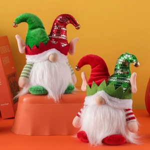 Lot de deux gnomes de Noël avec chapeaux à paillettes et cloches sur fond orange chaud