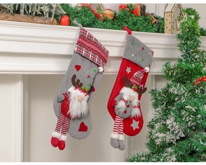 Hanging gray and red Christmas stockings with reindeer dolls on a white fireplace mantle