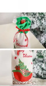 Detail of burlap Christmas wine gift bag with red ribbon and Merry Christmas print