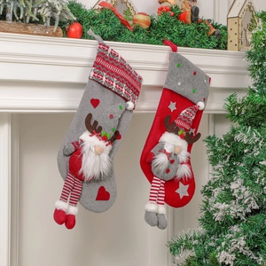Set of grey and red Christmas stockings with 3D gnome dolls hanging on a white fireplace