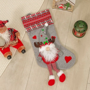Gray felt Christmas stocking with a 3D elf doll and knit accents on a wooden floor