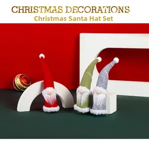 Three Christmas gnomes with long pointed hats in red, green and grey festive colors