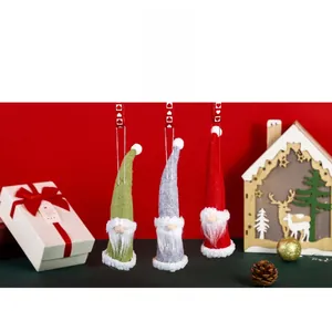 Close-up of three festive knitted Christmas gnomes with plush beards and heart straps