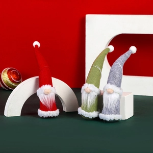 Three Christmas gnomes with pointed knit hats and white beards on decorative blocks
