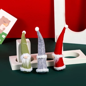 Three plush Christmas gnomes in green, grey, and red with long white beards for decoration