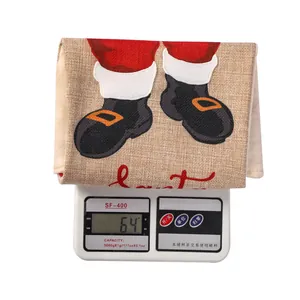 Detailed view of plaid Christmas stocking gift bag showing weight of 64g on digital scale