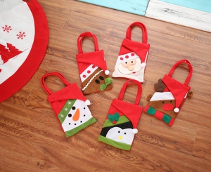 Detailed view of five Christmas felt gift bags with Santa and reindeer cartoon patterns