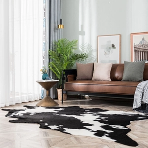 Detailed cowhide pattern rug on herringbone wood floor in modern living room setup