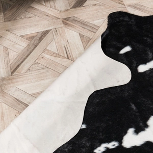 Detail of faux cowhide rug showing soft texture and natural edge on wooden floor