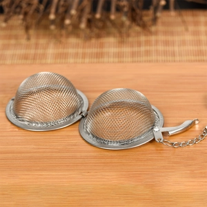Edelstahl-Teesieb mit Kette auf Holztisch für losen Tee und Gewürze zum Kochen