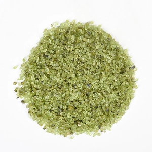 Natural peridot green crystal crushed stones arranged on a clean white background
