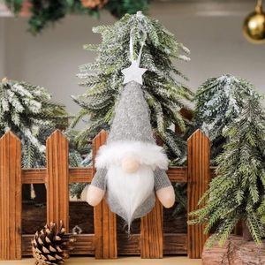 Knitted Christmas gnome ornament with silver star on a snowy festive tree branch