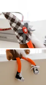Detail of rugby gnome showing plaid hat with miniature ball and striped bow accents