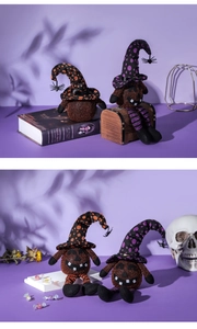 Detail of Halloween pumpkin plush dolls with wizard hats and hanging spiders on purple background