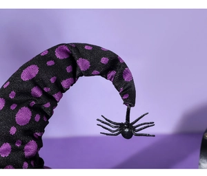 Detail of black fabric Halloween hat with purple polka dots and hanging spider charm