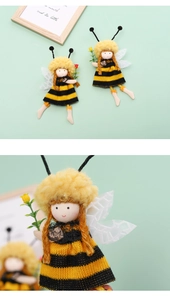 Détail de la poupée fée abeille avec chapeau à pompon jaune et robe en tricot rayée