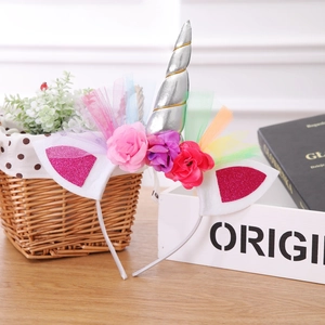 Close-up of unicorn headband with rainbow mesh, silver horn and colorful fabric flowers