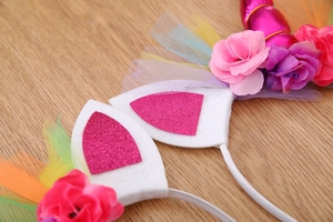 Detail of unicorn headband with rainbow mesh, felt ears, and fabric flowers for girls
