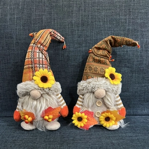 Detailansicht zweier Herbstwichtel mit Strickmützen, Ahornblättern und Sonnenblumen-Dekor