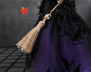 Détail de poupée de sorcière d'Halloween avec jupe en tulle violet et plumes noires