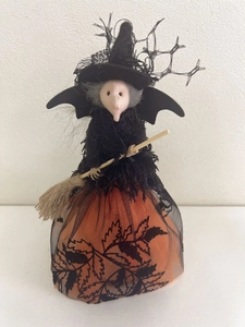 Détail de poupée de sorcière d'Halloween avec chapeau en dentelle et jupe à motif de feuilles