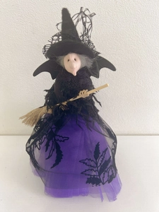 Détail de poupée sorcière Halloween avec plumes, jupe en tulle violet et balai