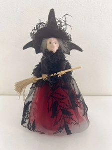 Détail d'une poupée de sorcière d'Halloween avec chapeau en dentelle noire et balai en bois