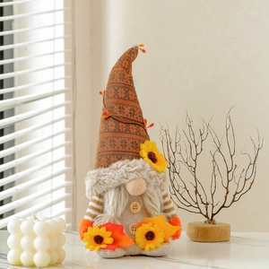Herbst-Zwergpuppe mit Sonnenblume und Ahornblatt für festliche Schaufensterdeko