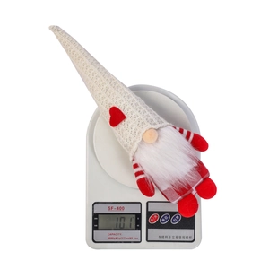 Detailed view of handmade Christmas gnome doll weighing 101g on electronic scale
