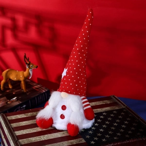Standing Christmas gnome with red knitted hat and white beard on a festive decor box