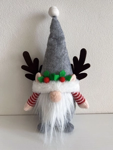 Detail eines Weihnachtsgnoms mit Rentiergeweih, Filzhut und Stechpalmenblättern