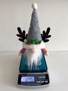 Nahaufnahme einer Weihnachts-Gnompuppe mit Geweih auf einer Digitalwaage bei 124,5g
