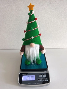 Detail eines Weihnachtsgnoms mit Baumhut, der 124 g auf einer Waage wiegt