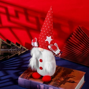 Nordic Christmas gnome plush with red star hat and white beard on a vintage book