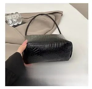 Détail de la texture cuir croco noir et du fond de sac résistant à l'usure quotidienne