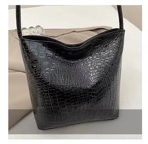 Gros plan sur la texture en similicuir crocodile noir d'un sac cabas élégant