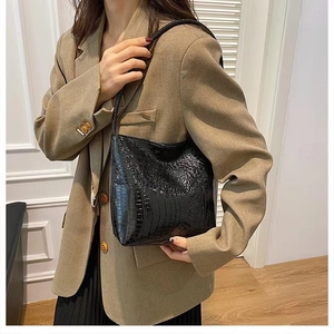 Sac fourre-tout noir à motif crocodile élégant associé à un blazer kaki pour le bureau