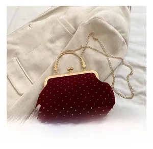 Retro red velvet evening handbag featuring white polka dots and golden metal handle